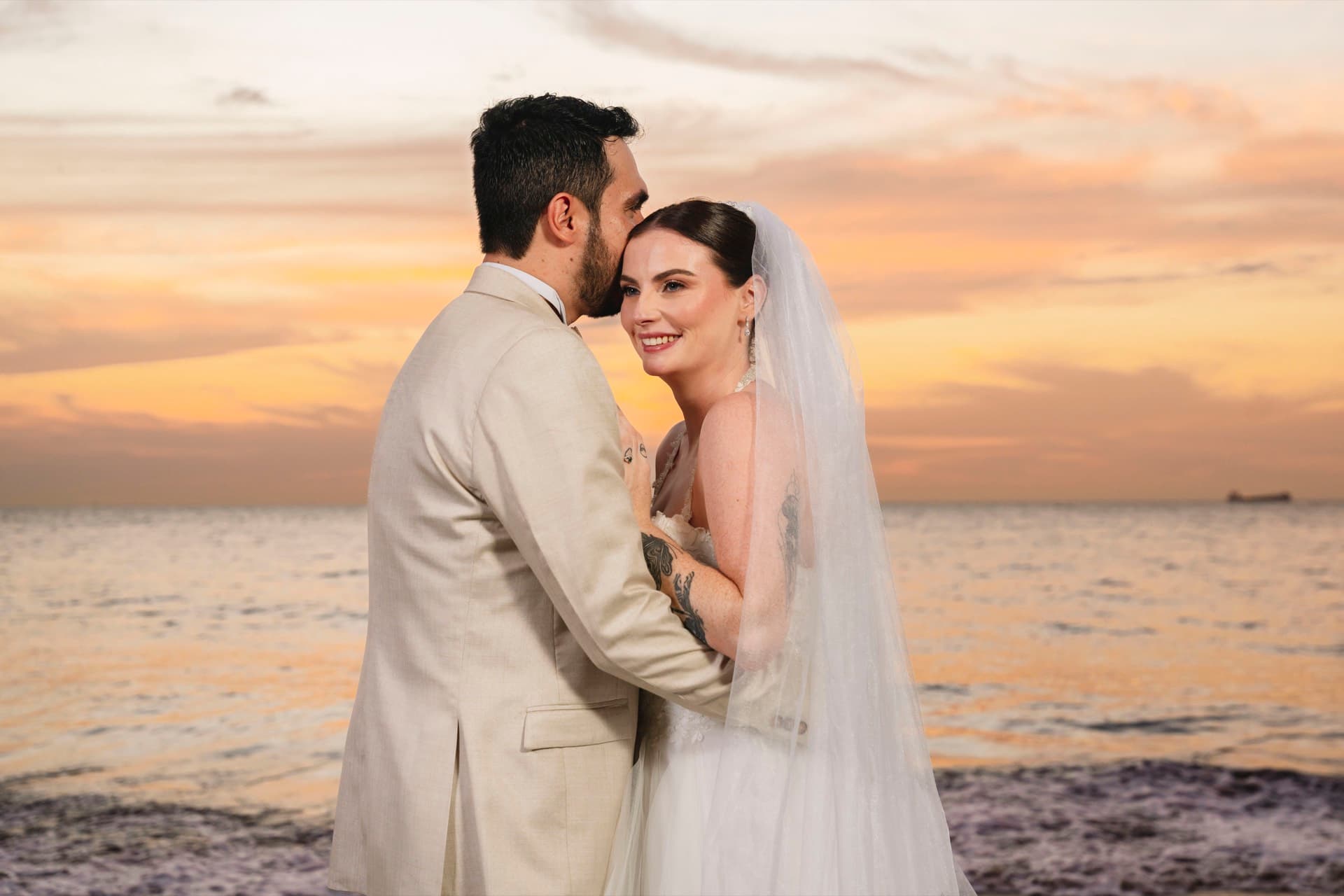 Pareja abrazada en la orilla al atardecer